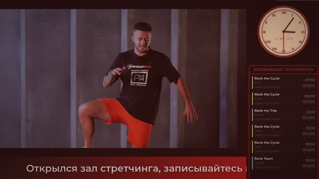 Тренер ведёт виртуальное занятие на экране клуба
